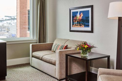 a living room with a couch and a table at Hotel Alex Johnson Rapid City, Curio Collection by Hilton in Rapid City