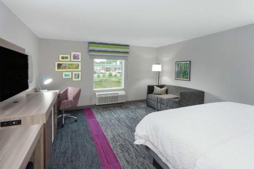 a hotel room with a bed and a flat screen tv at Hampton Inn & Suites Rocky Hill - Hartford South in Rocky Hill