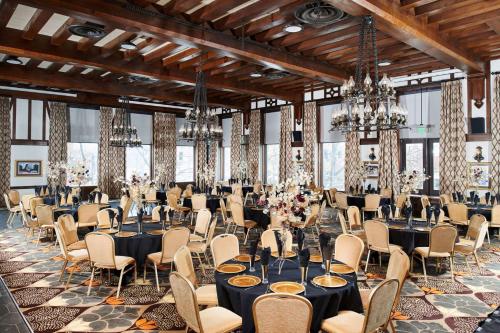 um salão de banquetes com mesas, cadeiras e lustres em Hotel Alex Johnson Rapid City, Curio Collection by Hilton em Rapid City