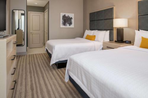 a hotel room with two beds and a flat screen tv at Homewood Suites By Hilton Belmont in Belmont