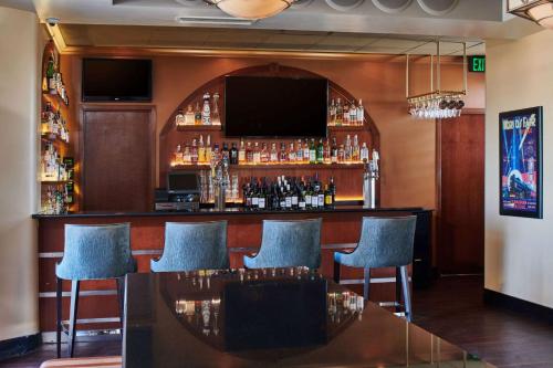 a bar with blue chairs and a flat screen tv at Hotel Alex Johnson Rapid City, Curio Collection by Hilton in Rapid City