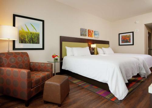 um quarto de hotel com uma cama grande e uma cadeira em Hilton Garden Inn Pittsburgh Downtown em Pittsburgh