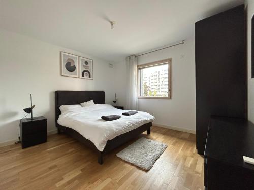 Un dormitorio con una cama grande y una ventana en Résidence les Iris - T2 au pied du tram en Annemasse