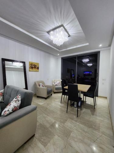 Crystalimmo في أغادير: غرفة معيشة مع أريكة وطاولة مع كراسي
