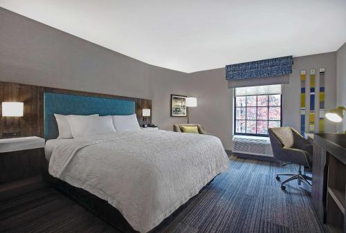 a hotel room with a bed and a television at Hampton Inn Westfield in Westfield