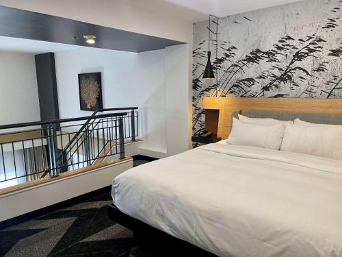 Un dormitorio con una gran cama blanca y una escalera en DoubleTree by Hilton Quebec Resort en Quebec