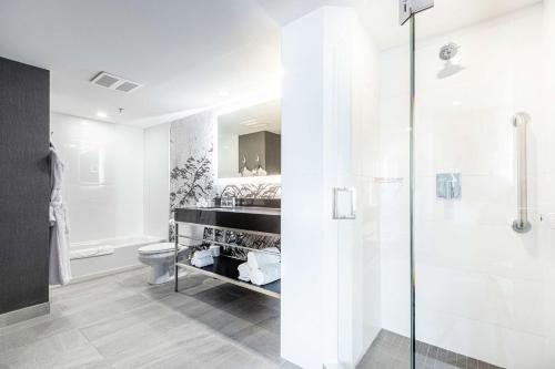 a white bathroom with a shower and a toilet at DoubleTree by Hilton Quebec Resort in Quebec City