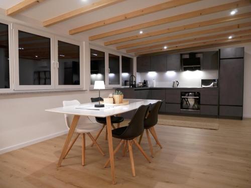 a kitchen and dining room with a white table and chairs at Klimatisierte Loftwohnung in Filderstadt