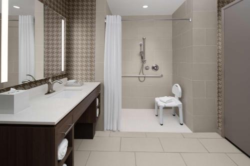 La salle de bains est pourvue d'une douche, d'un lavabo et de toilettes. dans l'établissement Home2 Suites By Hilton Carlsbad New Mexico, à Carlsbad