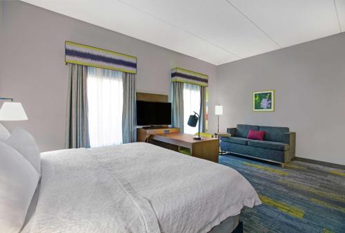 a hotel room with a bed and a couch at Hampton Inn & Suites Augusta West in Augusta