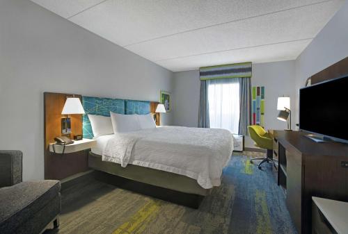 Habitación de hotel con cama y TV de pantalla plana. en Hampton Inn & Suites Augusta West, en Augusta