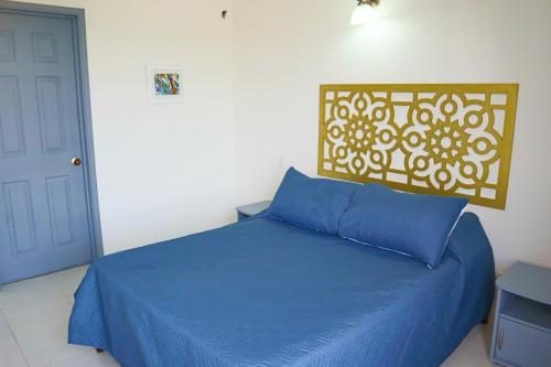 - une chambre avec un lit bleu et un oreiller bleu dans l'établissement Magico Apartamento con Piscina 1 Habitación PR65, à Montería