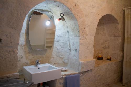 a bathroom with a sink and a mirror at Trulli Sarmenzanello in Noci