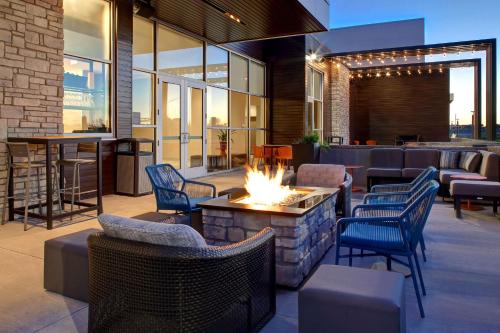 a patio with a fire pit and chairs and a bar at Hilton Garden Inn Cedar Rapids in Cedar Rapids