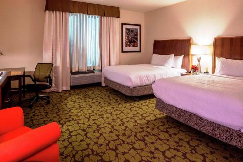 a hotel room with two beds and a desk at Hilton Garden Inn Uniontown in Uniontown