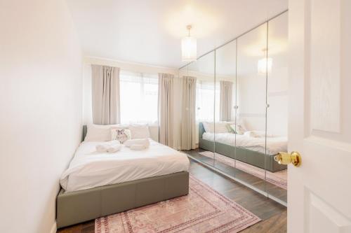 sypialnia z łóżkiem i lustrem w obiekcie Home near Excel, Stratford and Canary Wharf w Londynie