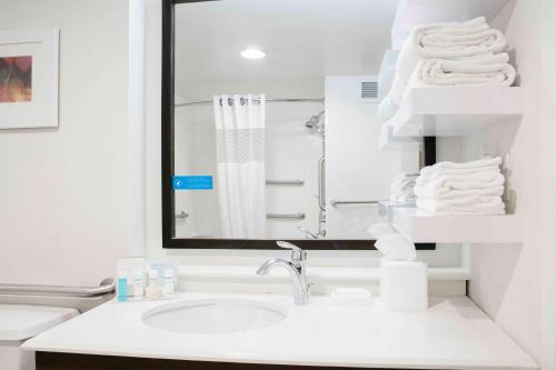 a bathroom with a sink and a mirror and towels at Hampton Inn Kansas City/Shawnee Mission in Shawnee