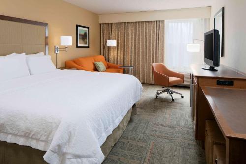 a hotel room with a bed and a television at Hampton Inn Kansas City/Shawnee Mission in Shawnee
