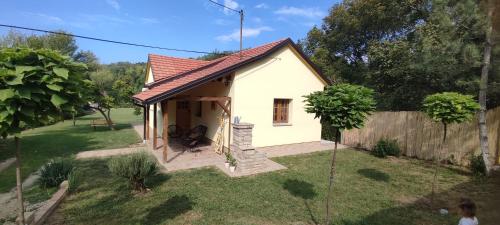 a small white house in a yard with a fence at Fruška house in Bešenovački Prnjavor