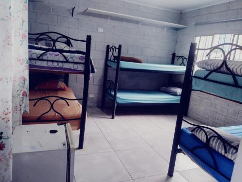 a room with three bunk beds in a room at CARIBONI in Guarujá