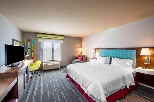 a hotel room with a bed and a flat screen tv at Hampton Inn & Suites Keller Town Center in Keller