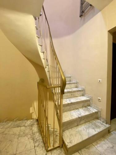 un escalier dans un bâtiment avec rampe en métal dans l'établissement Appartement - Carcassonne Centre, à Carcassonne