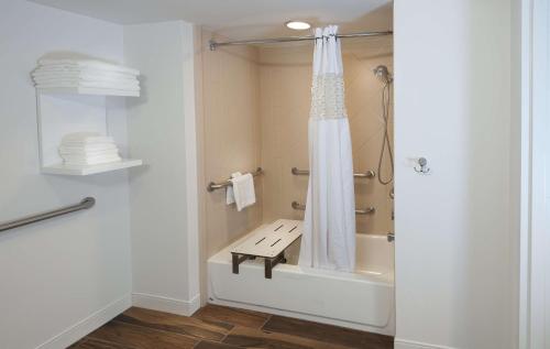 a bathroom with a shower with a bench in it at Hampton Inn Doylestown in Warrington