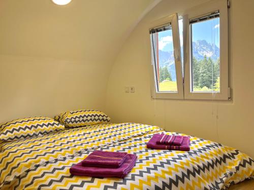 1 dormitorio con 1 cama con 2 toallas en Bungalows Fairy tale, en Žabljak