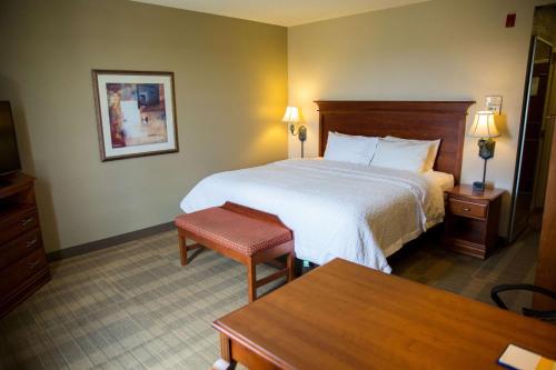 a hotel room with a bed and a table at Hampton Inn & Suites Grenada in Grenada