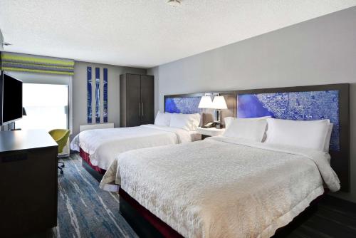 Cette chambre comprend 2 lits et une télévision à écran plat. dans l'établissement Hampton Inn Seattle/Southcenter, à Tukwila