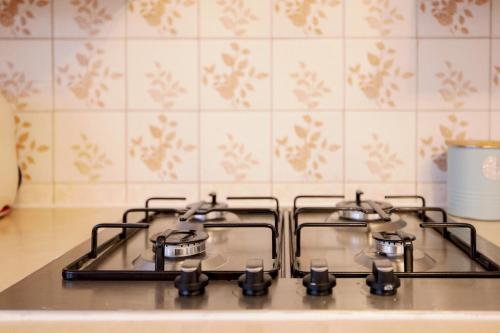 a stove top with four burners in a kitchen at Home near Excel, Stratford and Canary Wharf in London