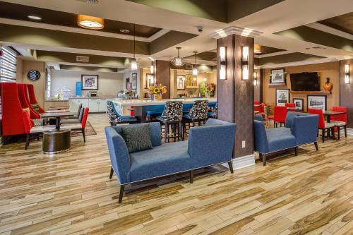 a waiting room with blue chairs and a bar at Hampton Inn San Francisco Airport in South San Francisco