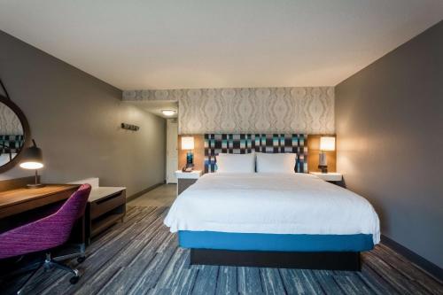 a hotel room with a large bed and a desk at Hampton Inn & Suites Herndon-Reston in Herndon