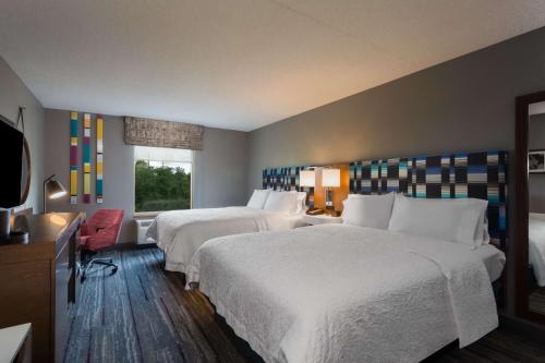 a hotel room with two beds and a window at Hampton Inn & Suites Herndon-Reston in Herndon