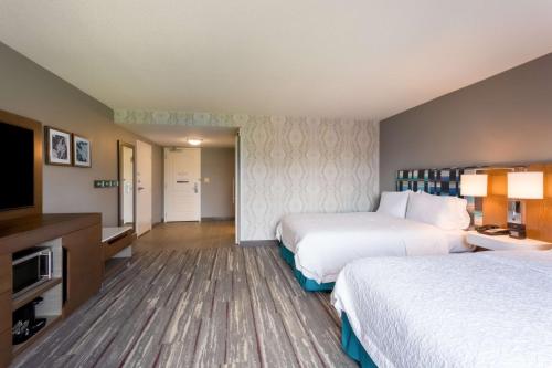 a hotel room with two beds and a flat screen tv at Hampton Inn & Suites Herndon-Reston in Herndon