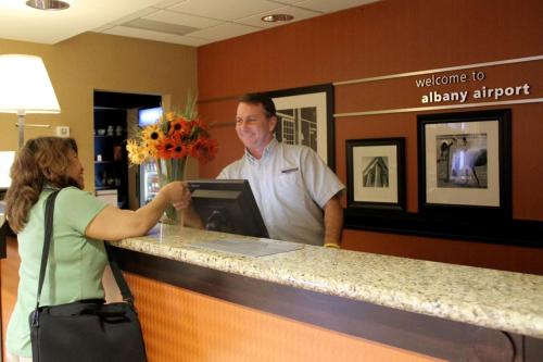 a man and a woman standing at a counter at Hampton Inn & Suites Albany-Airport in Latham