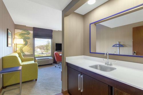 a hospital room with a sink and a mirror at Hampton Inn & Suites Albany-Airport in Latham