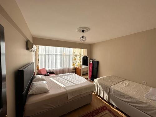 a bedroom with two beds and a window at Liman House Akçakale in Akcaabat