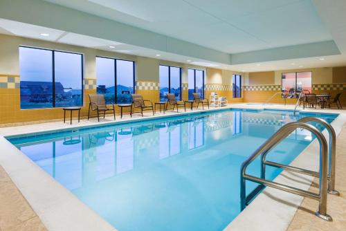 a pool in a hotel with chairs and tables at Hampton Inn and Suites Peoria at Grand Prairie in Peoria