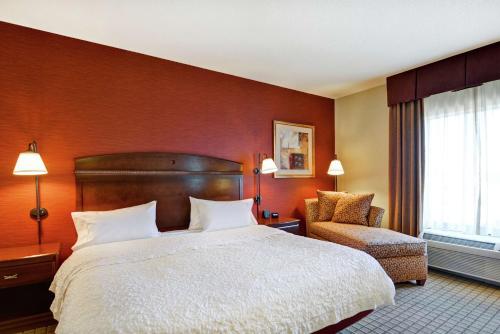 a hotel room with a bed and a chair at Hampton Inn and Suites Peoria at Grand Prairie in Peoria