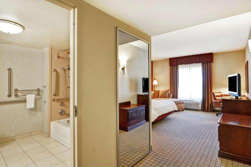 a hotel room with a bed and a bathroom at Hampton Inn and Suites Peoria at Grand Prairie in Peoria