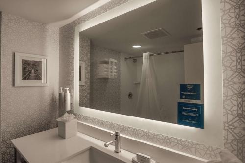 uma casa de banho com um lavatório e um espelho grande em Hampton Inn Springfield em Springfield