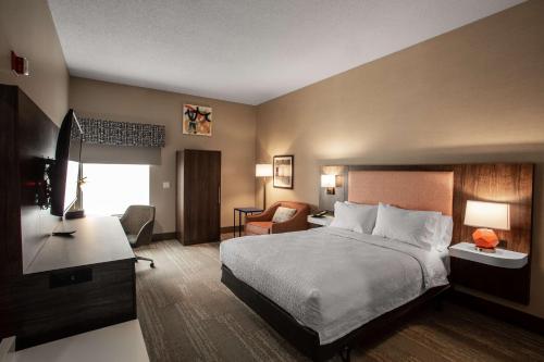 um quarto de hotel com uma cama e uma secretária em Hampton Inn Springfield em Springfield