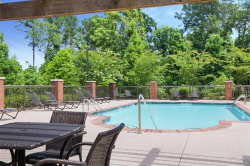 una piscina con sillas, una mesa y una mesa de picnic en Hampton Inn Columbus/South-Fort Benning, en Columbus