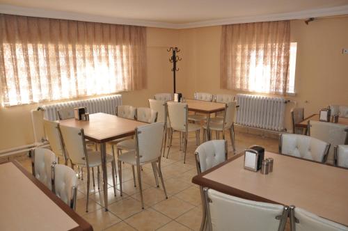 a dining room with tables and chairs and windows at Aygun Hotel Avanos in Avanos