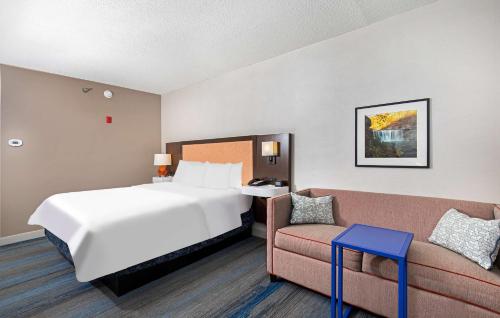 a hotel room with a bed and a couch at Hampton Inn Corbin in Corbin