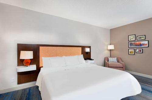 a bedroom with a large white bed and a chair at Hampton Inn Corbin in Corbin
