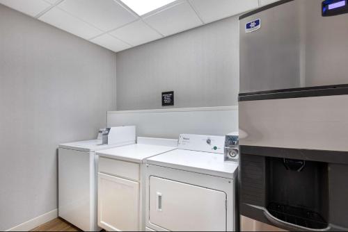 a kitchen with white counters and a refrigerator at Hampton Inn Corbin in Corbin