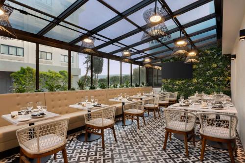 a restaurant with tables and chairs and glass ceilings at DoubleTree by Hilton San Francisco South Airport Blvd in South San Francisco