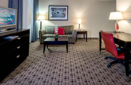a hotel room with a couch and a chair and a desk at Hampton Inn & Suites Montgomery-Downtown in Montgomery